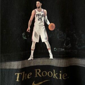 “The Nike Tee” in black. Size Men’s medium.  “The Rookie” graphics on the front.